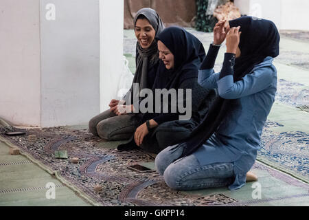 Junge Iranerinnen tragen Hijab Knien in der Schah-Moschee in Isfahan, Iran, um mit ihren Handys und Gebet Steinen (Salate) zu beten. Shah Moschee, auch bekannt als Imam-Moschee, nach der islamischen Revolution von 1979 im Iran und in Jaame umbenannt "Abbasi Moschee ist eine Moschee in Isfahan, Iran, stehend in der Südseite des Naghsh-e Jahan Quadrat. Stockfoto