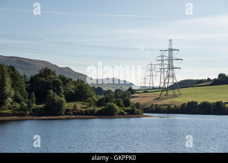 Pylone neben den Stauseen im Norden Englands Longdendale-Tal. Blick über Bottoms Reservoir an einem Sommermorgen. Stockfoto