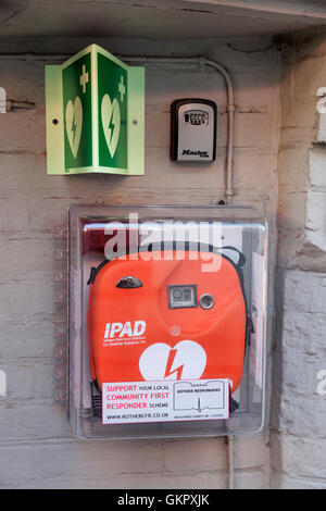 Defibrillator außerhalb auf eine öffentliche Wand in einem englischen Dorf. Stockfoto