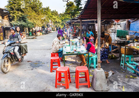 Typischen Morgen Straßenszene auf dem Jademarkt, Mandalay, Myanmar (Burma), Menschen vor Ort mit Frühstück im am Straßenrand Cafés Stockfoto