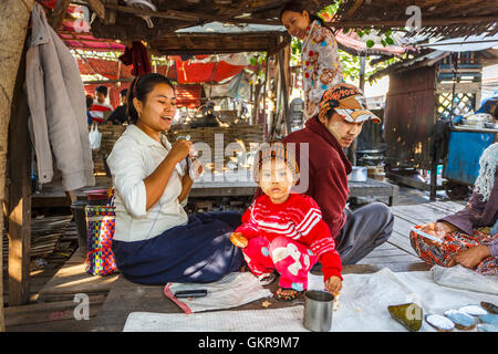 Fröhliche Familie der Schausteller mit einem niedlichen kleinen Jungen tragen Thanaka, Jade-Markt, Mandalay, Myanmar (Burma) Stockfoto