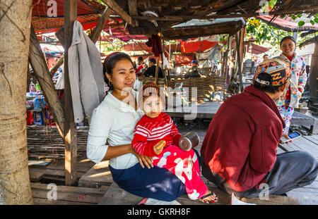 Standbesitzer Familie mit einem süßen jungen tragen Thanaka, Jade-Markt, Mandalay, Myanmar (Burma) Stockfoto