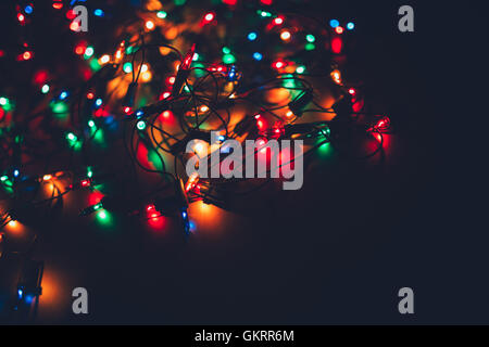 Weihnachtsbeleuchtung auf dunklem Hintergrund. Dekorative Girlande. Getönte Foto Stockfoto