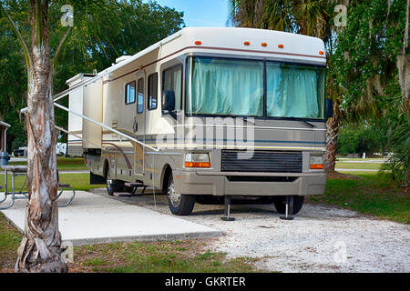 Vorder- und Seitenansicht Ansicht von 32ft Klasse A Wohnmobil mit Slideouts in einem Park in Florida Stockfoto