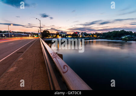 Schiene trennt Strasse und Wasser mit Stadt im Hintergrund. Stockfoto