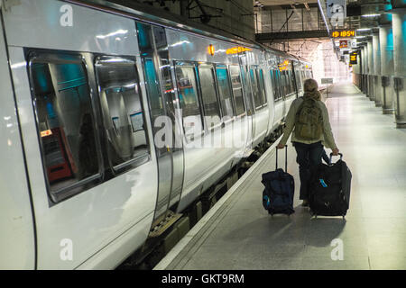 Stansted Express Zug, Tourist, Touristen, Gepäck, Gepäck, Taschen, auf, Plattform am Flughafen Stansted vor der Überschrift zu Liverpool Street, London, England, Großbritannien Stockfoto