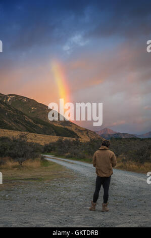 Menschen nehmen Foto von Regenbogen über Berg in der Nähe von Lake Pearson, Neuseeland Stockfoto