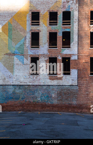 Verlassene Gebäude in der Innenstadt von Detroit. Fassade aus Ziegeln, teils mit einem bunten Gemälde gemacht. Zerbrochene Fensterscheiben. Stockfoto