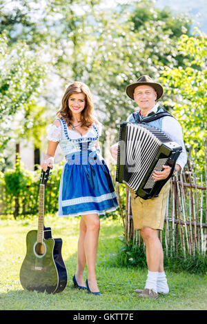 Paar in bayerischer Tracht mit Gitarre und Akkordeon Stockfoto