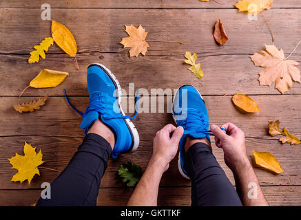 Nicht erkennbare Läufer in Sportschuhen, die Schnürsenkel zu binden. Herbst le Stockfoto