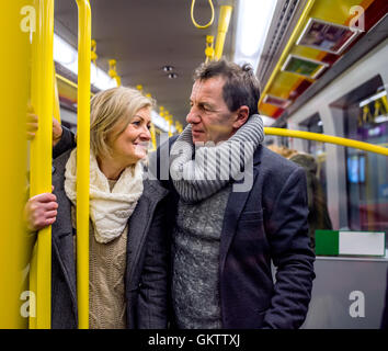 Älteres Paar steht in einer überfüllten u-Bahn Stockfoto