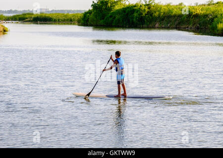 Ein 12-14 Jahre alten kaukasischen junge auf einem Paddle Board auf dem North Canadian River in der Nähe von Bethanien und Oklahoma City, Oklahoma, USA. Stockfoto