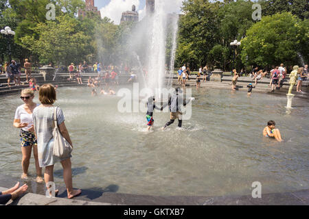 New Yorker und Besucher genießen den Brunnen im Washington Square Park in Greenwich Village in New York auf Samstag, 13. August 2016. Glühende Hitze und klebrige Feuchtigkeit sind über das Wochenende die Temperatur fühlen Weg über 100 Grad F. eingezogen Die Stadt hat eine beratende Hitze mit Kühlung Zentren eröffnet in den fünf Boroughs ausgestellt. (© Richard B. Levine) Stockfoto