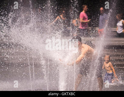 New Yorker und Besucher genießen den Brunnen im Washington Square Park in Greenwich Village in New York auf Samstag, 13. August 2016. Glühende Hitze und klebrige Feuchtigkeit sind über das Wochenende die Temperatur fühlen Weg über 100 Grad F. eingezogen Die Stadt hat eine beratende Hitze mit Kühlung Zentren eröffnet in den fünf Boroughs ausgestellt. (© Richard B. Levine) Stockfoto