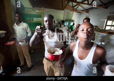 Eine Gruppe von jungen Essen Mittagessen in ihre Wohnräume in der Schule in Uganda Stockfoto