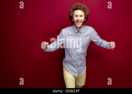 Lächelnde stilvollen Mann Arme an den Seiten Stockfoto