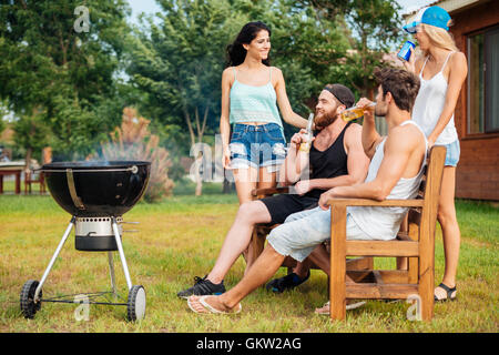 Gruppe junger Teenager im Chat während der Vorbereitung der Barbecue-Grill in Parkzone Stockfoto