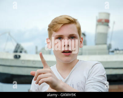 Teenager Boy nach oben mit dem Finger auf ein Statement Stockfoto