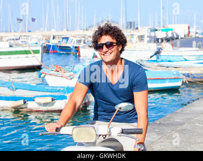 Italienischer Jugendlicher auf Vespa Roller lächelnd Stockfoto