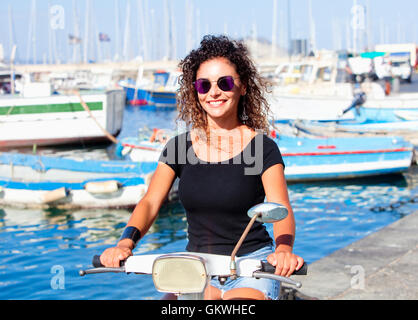 Junge Italienerin auf Vespa Roller lächelnd Stockfoto