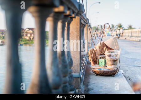 Vietnamesin mit Körben auf Hoi an einer Brücke Stockfoto