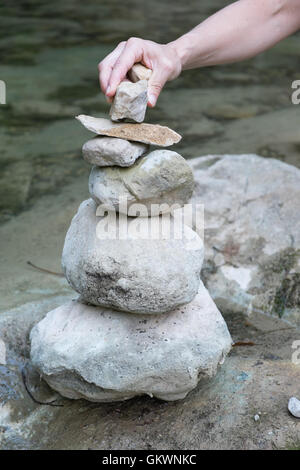 Ausgleich in den Bach La Blanque, einem Nebenfluss des Sals Stein. Setzen von Steinen in einem Haufen entlang Flussbett. Aude, Südfrankreich. Stockfoto