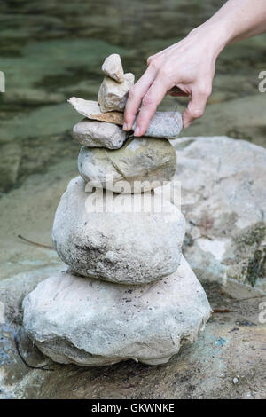 Ausgleich in den Bach La Blanque, einem Nebenfluss des Sals Stein. Setzen von Steinen in einem Haufen entlang Flussbett. Aude, Südfrankreich. Stockfoto