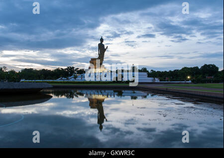 Wander-Buddha-Statue und Reflexion über Wasser bei Buddhamonthon (Phutthamonthon), buddhistische Park in Nakhon Pathom, Thailand, in tw Stockfoto