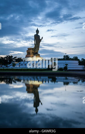 Wander-Buddha-Statue und Reflexion über Wasser bei Buddhamonthon (Phutthamonthon), buddhistische Park in Nakhon Pathom, Thailand, in tw Stockfoto