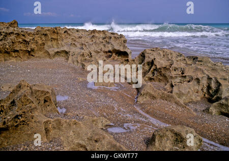 Es weht Rocks Beach in Jupiter, Florida Funktionen einzigartigen roten Felsformationen, ergänzt durch Küstenlinie Breakers und blue Surf. Stockfoto