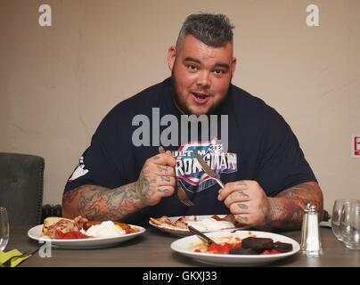 Irische Strongman Sean O'Hagan steckt in einem Frühstück der Champions bei Man Vs Food-Veranstaltung vor der ultimativen Strongman Riesen Wochenende im Crumlin Road Gefängnis in Belfast. Stockfoto