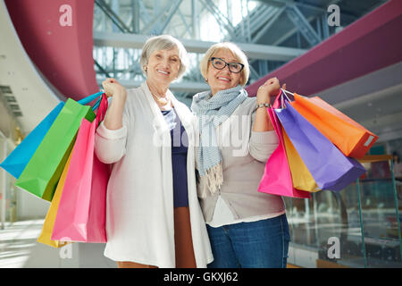 Zufriedene Käufer mit Paperbags Blick in die Kamera Stockfoto