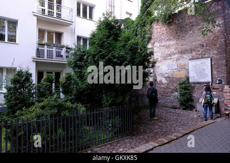 Touristen auf den verbleibenden Teil des Warschauer Ghettos Wand in einem Hinterhof eines Hauses in Sienna Street in Warschau Polen Stockfoto