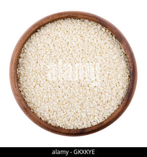 Sesam in einer Holzschale auf weißem Hintergrund. Getrocknete Samen mit entfernten Samenhüllen. Sesamum, auch genannt Benne. Stockfoto