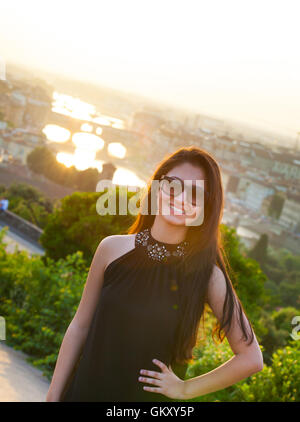 Young Teen bei Sonnenuntergang in Florenz, Ponte Vecchio auf dem Hintergrund. Stockfoto