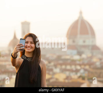 Young Teen nimmt eine Selfie bei Sonnenuntergang in Florenz, Dom Santa Maria del Fiore im Hintergrund. Stockfoto