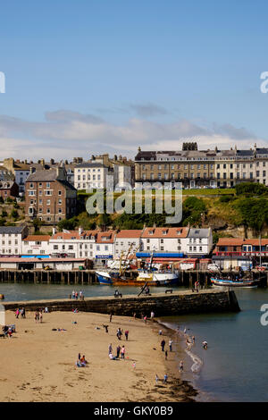 Urlauber am Strand im Hafen von Whitby, North Yorkshire, England Stockfoto