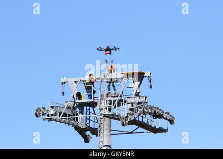 El Alto, Bolivien, 23. August 2016. Ein Techniker erreicht für eine Drohne, die trägt ein synthetisches Lichtkabel zwischen den Masten einer neuen Seilbahn / Gondel lift derzeit im Bau zwischen dem Rio Seco und La Ceja in El Alto. Dies ist der erste Teil des Prozesses, das endgültige Stahlseil zu installieren, das Gondeln tragen wird. Die Seilbahn ist Teil einer zweiten Phase der Seilbahn-Linien, die Teil eines ehrgeizigen Projekts um Verkehrsstaus zu lindern sind. 3 Routen aus der ersten Phase sind bereits zwischen den Städten La Paz und El Alto in Betrieb. Bildnachweis: James Brunker / Alamy Live News Stockfoto