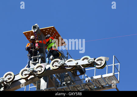 El Alto, Bolivien, 23. August 2016. Techniker installieren ein synthetisches Lichtkabel auf dem Pylon eine neue Seilbahn / Gondel lift derzeit im Bau zwischen dem Rio Seco und La Ceja in El Alto. Dies ist der erste Teil des Prozesses, das endgültige Stahlseil zu installieren, das Gondeln tragen wird. Diese Seilbahn gehört zu einer zweiten Phase der Seilbahn-Linien, die Teil eines ehrgeizigen Projekts um Verkehrsstaus zu lindern sind. 3 Routen aus der ersten Phase sind bereits zwischen den Städten La Paz und El Alto in Betrieb. Bildnachweis: James Brunker / Alamy Live News Stockfoto