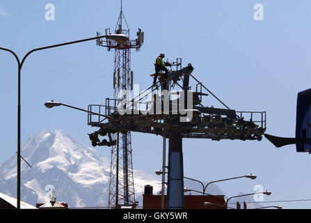 El Alto, Bolivien, 23. August 2016. Ein Techniker überprüft eine Drohne, die verwendet wird, um ein synthetisches Lichtkabel zwischen den Masten einer neuen Seilbahn tragen / Gondelbahn, die befindet sich im Aufbau. Dies ist der erste Teil des Prozesses, das endgültige Stahlseil zu installieren, das Gondeln tragen wird. Seilbahn zwischen Rio Seco und La Ceja in El Alto gehört zu einer zweiten Phase der Seilbahn-Linien, die Teil eines ehrgeizigen Projekts um Verkehrsstaus zu entlasten. 3 Routen aus der ersten Phase sind bereits zwischen den Städten La Paz und El Alto in Betrieb. Mt Huayna Potosi ist im Hintergrund Stockfoto