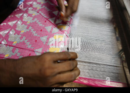 In der Nähe von Dhaka, Bangladesh. 24. August 2016. Handwebstuhl Weber webt Jamdani Saree auf einem traditionellen hölzernen Hand Webstuhl in Tarabo, in der Nähe von Dhaka, Bangladesh, 24. August 2016. Jamdani ist eines der feinsten Musselin Textilien von Bengalen, im Bezirk von Dhaka, Bangladesch seit Jahrhunderten hergestellt. Die historische Produktion von Jamdani wurde durch kaiserliche Optionsscheine der Mughal Kaiser bevormundet. Unter britischen Kolonialismus Bengali Jamdani und Musselin Branchen schnell sank aufgrund der kolonialen Import Richtlinien Begünstigung industriell hergestellt Textilien. In den letzten Jahren hat die Produktion von Jamdani witne Stockfoto