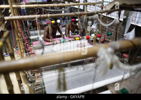 In der Nähe von Dhaka, Bangladesh. 24. August 2016. Handwebstuhl Weber webt Jamdani Saree auf einem traditionellen hölzernen Hand Webstuhl in Tarabo, in der Nähe von Dhaka, Bangladesh, 24. August 2016. Jamdani ist eines der feinsten Musselin Textilien von Bengalen, im Bezirk von Dhaka, Bangladesch seit Jahrhunderten hergestellt. Die historische Produktion von Jamdani wurde durch kaiserliche Optionsscheine der Mughal Kaiser bevormundet. Unter britischen Kolonialismus Bengali Jamdani und Musselin Branchen schnell sank aufgrund der kolonialen Import Richtlinien Begünstigung industriell hergestellt Textilien. In den letzten Jahren hat die Produktion von Jamdani witne Stockfoto