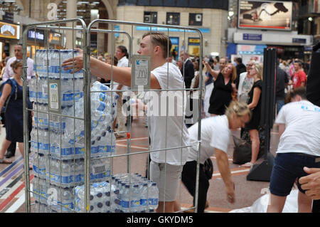 London, UK. 24. August 2016 kostenlos Notversorgung mit Trinkwasser durch Mitglieder der Firma Bahnpersonal überhitzten Pendler helfen ausgehändigt. Viele südöstliche Züge haben keine Klimaanlage Credit: Daniel Markham/Alamy Live News Stockfoto