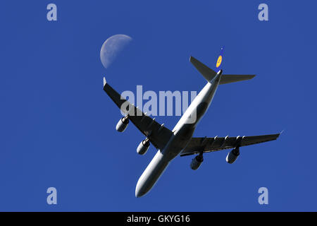 Essen, Deutschland. 25. August 2016. Ein Flugzeug der Lufthansa, Typ Airbus A340, vorbei an den Mond am blauen Himmel fliegt, während seine Landung in Essen, Deutschland, 25. August 2016. Foto: Federico Gambarini/Dpa/Alamy Live News Stockfoto