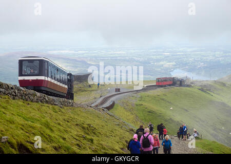 Zug absteigend Snowdon Mountain Railway über Clogwyn Station und Menschen zu Fuß auf Llanberis Pfad auf Mt Snowdon in Snowdonia (Eryri). Wales UK Stockfoto