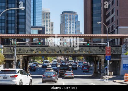 Mittags Verkehr unterquert das Willkommensschild auf der Metro-North Railroad Überführung in downtown White Plains, New York. Stockfoto