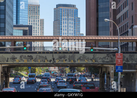 Mittags Verkehr unterquert das Willkommensschild auf der Metro-North Railroad Überführung in downtown White Plains, New York. Stockfoto