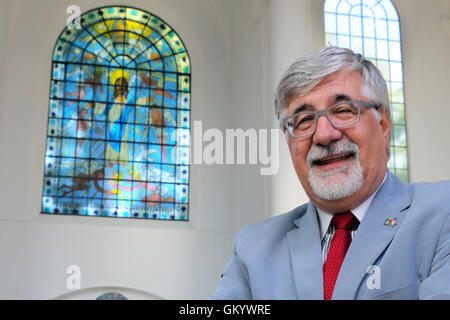 Eines der zwei Kirchenfenster von der New Yorker Pop-Künstler JAMES RIZZI (* 1950 +2011) in der Kirche Kreuzeskirche in Essen, Deutschland. Pfarrer Steffen Hunder steht unter einem neuen Fenster in seiner Kirche. Stockfoto