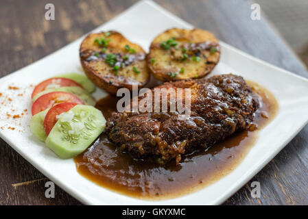 berühmte Cordon Bleu paniert gebratenes Huhn Soße und Kartoffeln essen Stockfoto