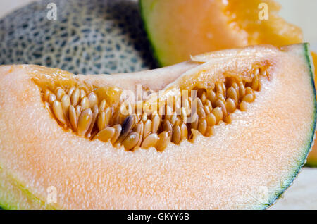 Cucumis Melo oder Melone mit Hälfte und Samen auf Holzplatte (andere Namen sind León, Cantaloup, Honigtau, Crenshaw, Casaba, Pe Stockfoto